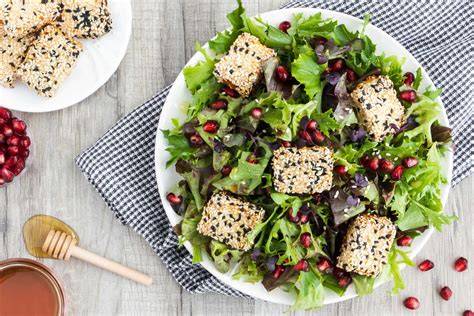 Sesam- und Kernpralinen mit Feta, angerichtet mit Basilikum