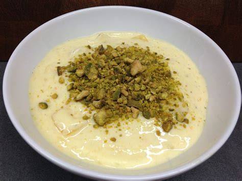Shrikhand Dessert in Schalen, garniert mit Safran und Pistazien