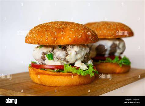 Signature Trüffel Burger: Serviervorschlag auf Holzbrett mit hausgemachten Saucen und Toppings