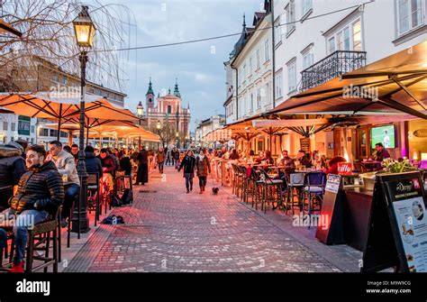 Simon-Dach-Straße bei Nacht mit Cafés und Passanten