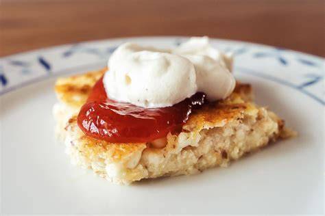 Småländsk Ostkaka - traditionelle Servierweise mit Marmelade und Sahne