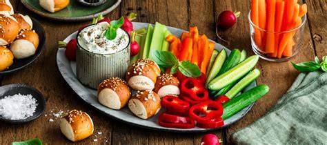 Snackteller mit ofenfrischen Brötchen, Marmelade und frischem Gemüse