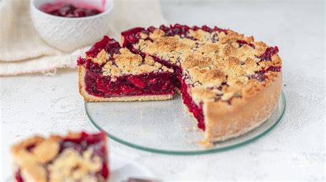 Sommerliche Kirschen im Korb und aufgeschnittener Kirschkuchen mit Baiserhaube