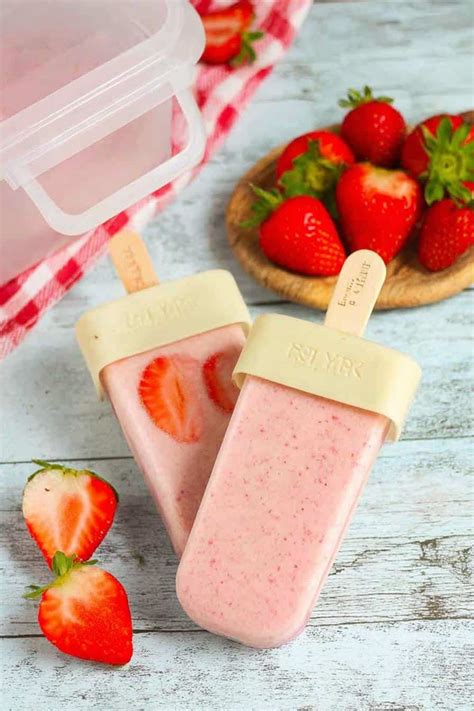 Sommerliche Nahaufnahme von Erdbeer-Bananen-Eis am Stiel mit frischen Früchten