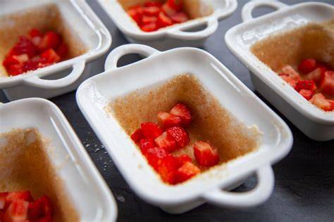 Soufflé-Zubereitung: Förmchen fetten und mit Zucker ausstreuen