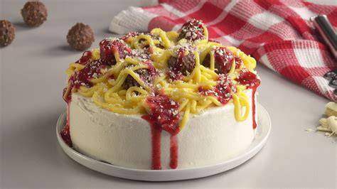 Spaghetti-Kuchen aufgeschnitten mit Erdbeersoße und weißer Schokolade