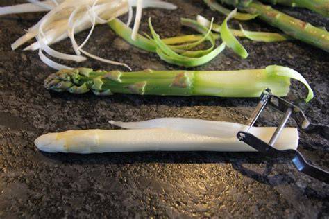 Spargel wird geschält und die Enden abgeschnitten, Schnitttechnik zeigt Detailansicht