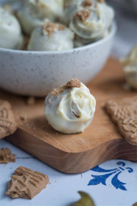 Spekulatius-Marzipan Pralinen auf schwarzem Teller, verziert mit Keksbröseln