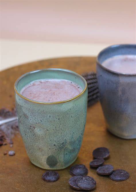 Sprühflasche mit Schoko-Sprühsahne neben Tasse Kakao