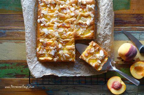 Springform mit fertigem Pfirsichkuchen und gehobelten Mandeln