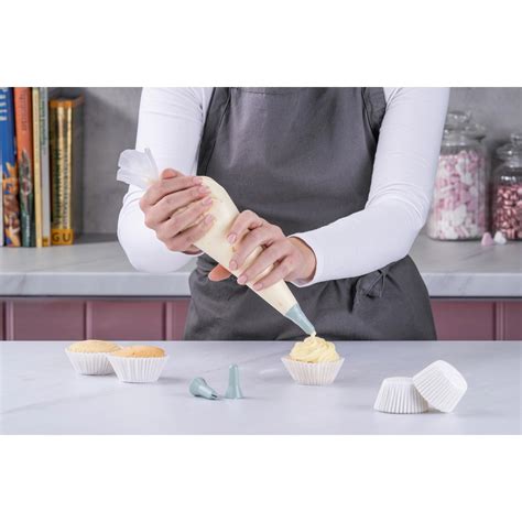 Spritzbeutel mit Sterntülle beim Aufdressieren von Cupcakes