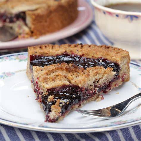 Stück Heidelbeer-Joghurt-Torte auf einem Kuchenteller mit Dekoration