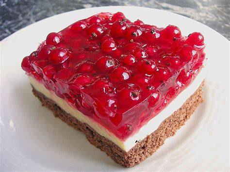 Stück Johannisbeerkuchen mit Schmand und Pudding auf Teller