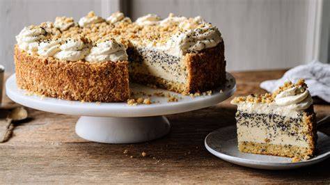 Stück Marzipan-Mohn-Torte auf einer Tortenplatte, daneben Backzubehör