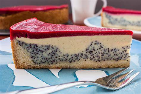 Stück Mohn-Käsekuchen mit Himbeerspiegel auf Teller