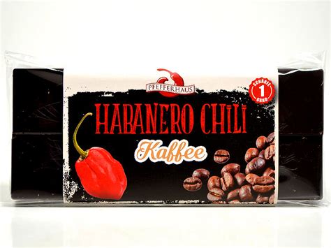 Stück Zartbitterschokolade und Chili auf Holzbrett