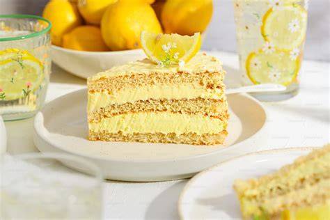 Stück Zitronen-Joghurt-Torte auf Teller mit Minze