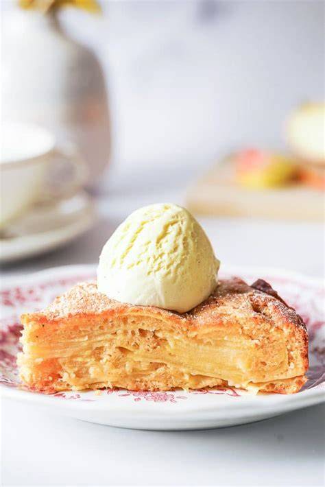 Stück gestürzter Apfelkuchen mit einer Kugel Vanilleeis auf einem Teller