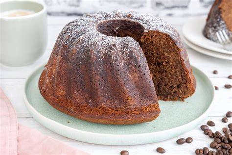 Stück saftiger Kaffeekuchen, angerichtet auf einem Kuchenteller mit frischem Kaffee