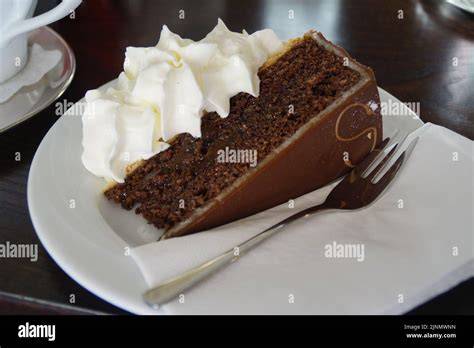 Stück veganer Apfel-Karamell-Kuchen auf Teller mit Schlagsahne und Zimtdekor