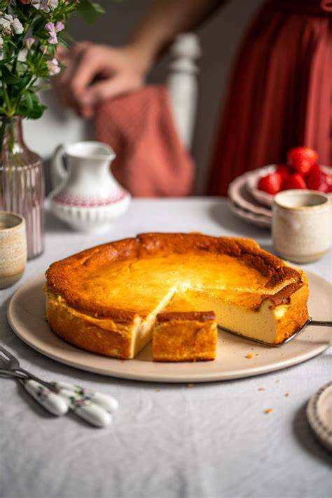 Stück vom perfekten Käsekuchen auf Vintage-Teller mit Tasse Kaffee