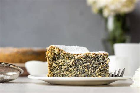 Stücke Mohnkuchen auf Teller mit Puderzucker
