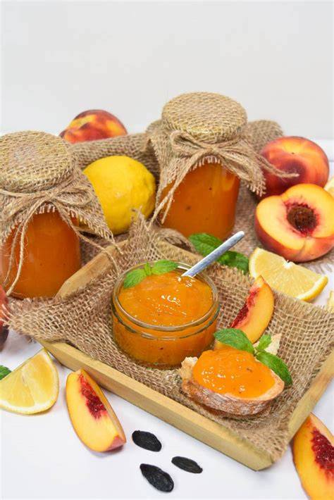 Sterilisierte Marmeladengläser gefüllt mit Pfirsichmarmelade