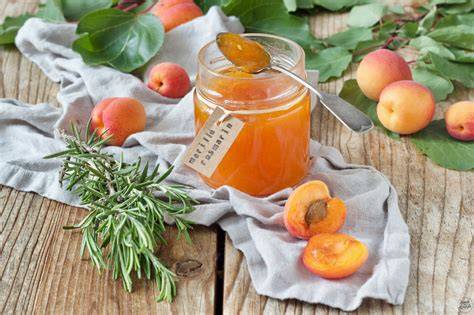 Sterilisiertes Einmachglas mit frischer Marillenmarmelade