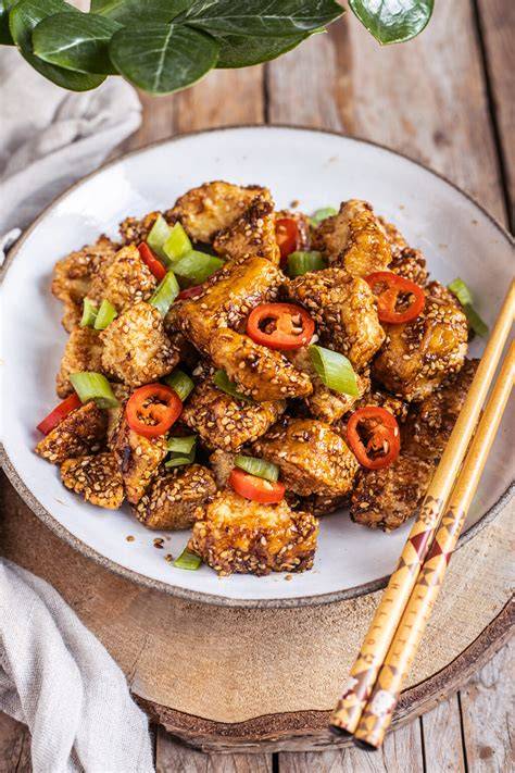 Sticky Sesam Tofu auf Teller mit Limette und Frühlingszwiebeln