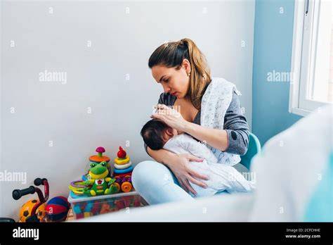 Stillende Mutter beobachtet Säugling nach dem Essen