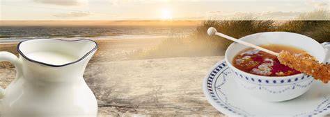 Stilvolle Tasse Ostfriesentee neben Stück Käsekuchen