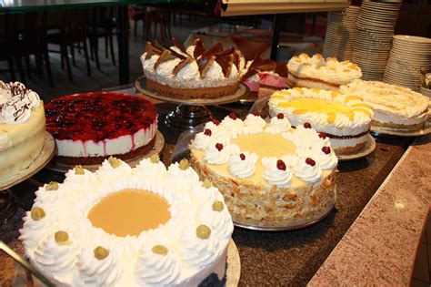 Stilvolles Café mit Etagere, Tortenauswahl und offenem Backbereich