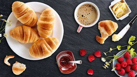 Stimmungsbild: Frühstückstisch mit Mini- und klassischen Croissants, Marmelade, Kaffee