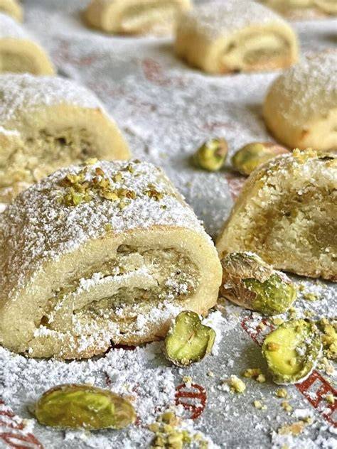 Stimmungsvolle Aufnahme: Marzipanplätzchen, Pistazien und Puderzucker auf rustikalem Blech
