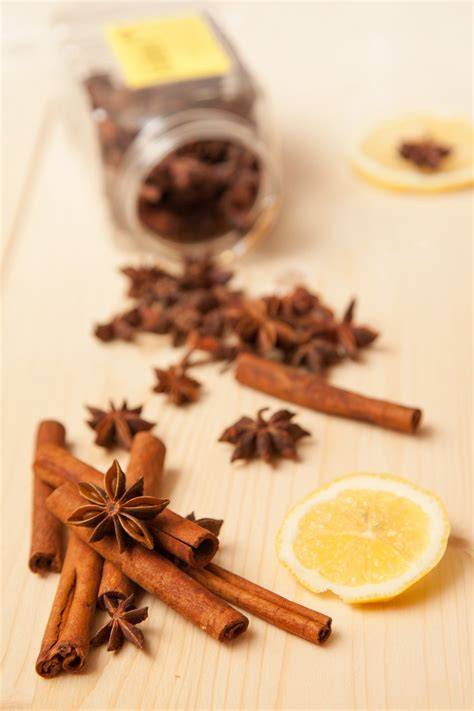 Stimmungsvolle Dessertszene: Glühweincreme in Gläsern, Gewürze (Zimt, Sternanis), Orangenzeste