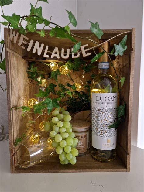 Stimmungsvolle Geschenkidee: Wein, Pralinen und edle Verpackung auf einem Holztablett
