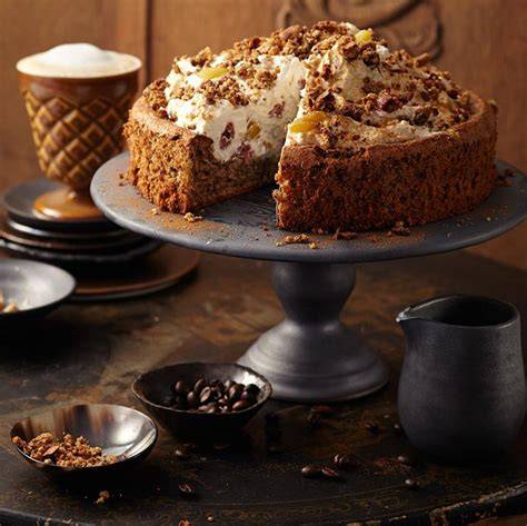 Stimmungsvolle Kuchentafel mit Torte, Tarte, Muffins und Kaffee