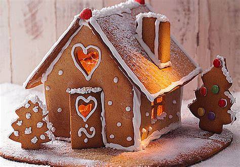 Stimmungsvolle Lebkuchen-Deko: Herzen, Männchen und ein verziertes Häuschen auf Holzbrett