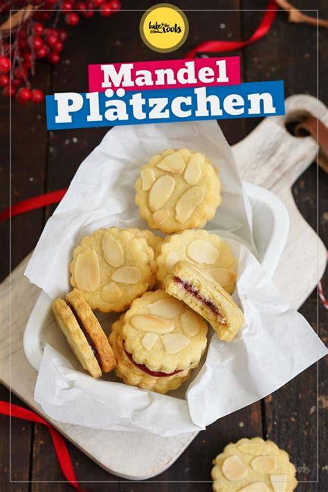 Stimmungsvolle Nahaufnahme von Mandelplätzchen mit Marmelade auf einem weihnachtlichen Teller