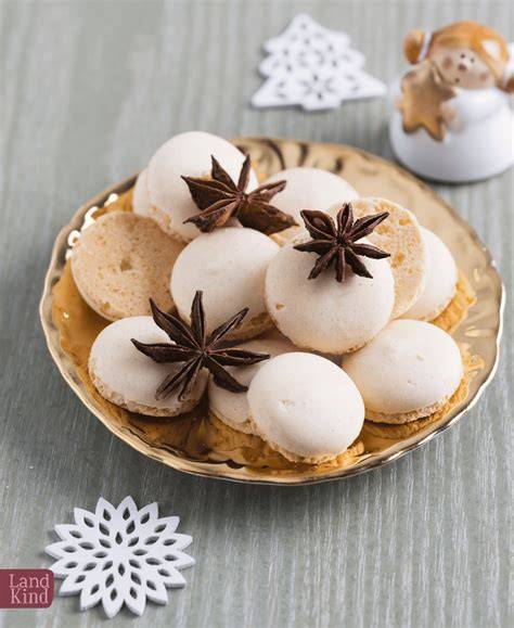 Stimmungsvolle Nahaufnahme von Nougat-Baiser-Plätzchen auf einem Teller mit weihnachtlicher Deko
