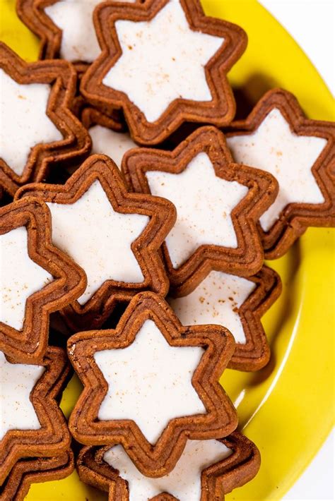 Stimmungsvolle Weihnachtskekse mit weißer Schokolade auf einem Teller, Zutaten und Backutensilien