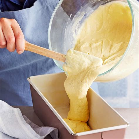 Stimmungsvolles Stillleben: kleine Springform, Rührteig, Zutaten und fertiger Mini-Kuchen