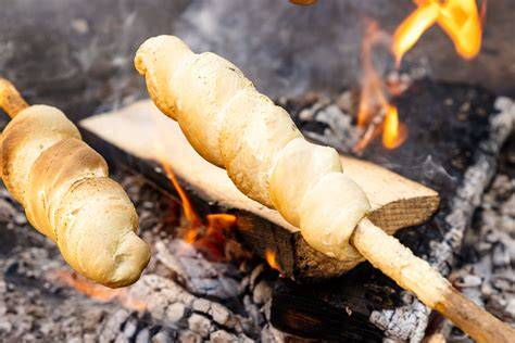 Stockbrot am Stock neben Glut - fertiges Ergebnis