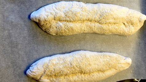 Stollen-Backen: Teiglinge in Stollenhauben auf dem Backblech