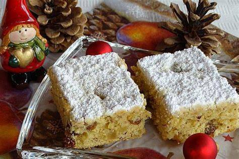 Stollenkuchen vom Blech mit Marzipan, Rosinen und Puderzucker auf Backpapier serviert
