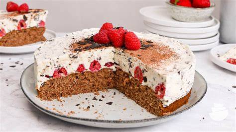 Stracciatella Torte mit Himbeeren - Anschnitt mit Sahnecreme und Schokostückchen