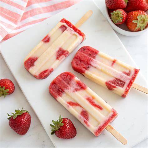 Strawberry Cheesecake Popsicles auf Holzbrett
