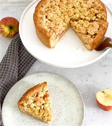 Streusel auf Apfelwein-Kuchen verteilen und goldbraun backen
