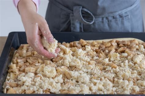 Streusel auf dem Apfelkuchen verteilen