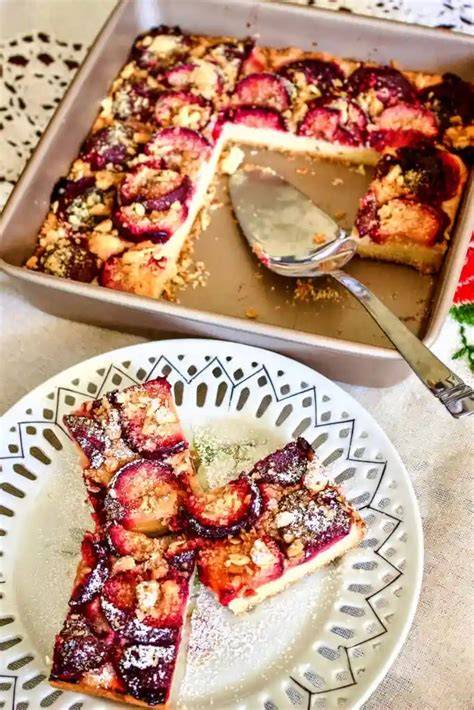Streusel werden auf den Pflaumenkuchen gegeben